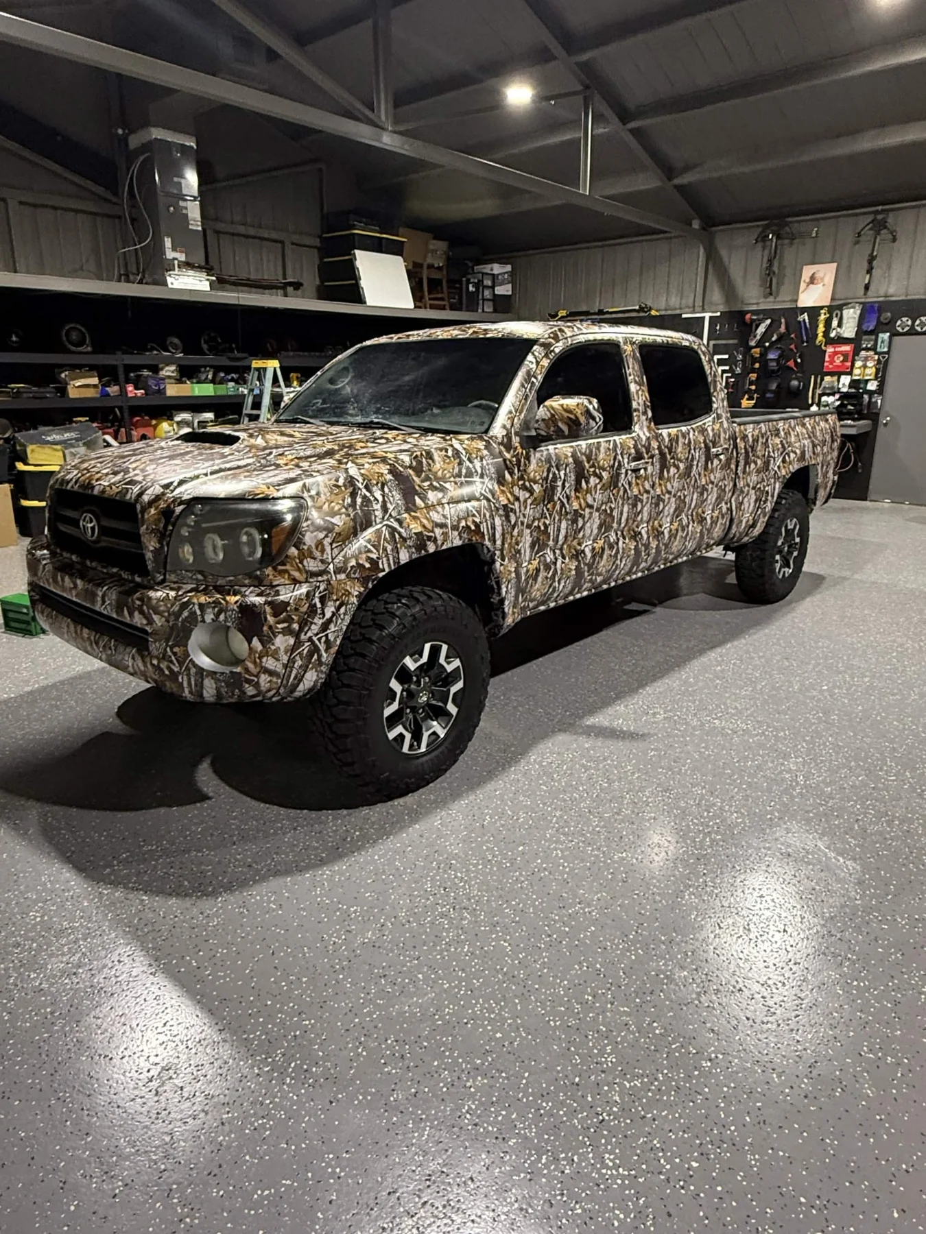 Camouflage wrapped pickup truck viewed from the front-left