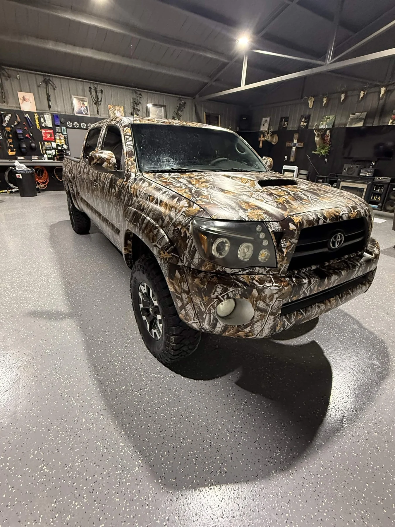 Camouflage wrapped pickup truck viewed from the front-right